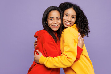 Two young smiling little kid teen girls women they wear red yellow hoodie casual clothes hug cuddle...