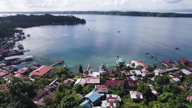 Aerial view showcasing colorful houses along the bay of Bastimentos Island, Panama, in the Bocas del Toro District. pull back, rising shot