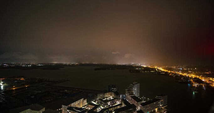 Time lapse of storm clouds moving over the night lit Kulosaari island, Helsinki