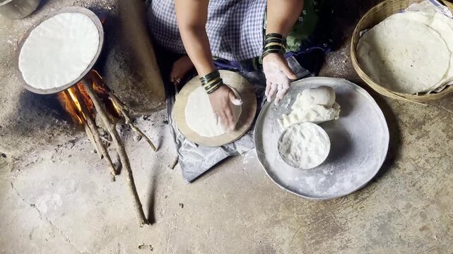 Lady is giving shape to the bhakri dough with the help of her hands by rotating it Maharashtra India 4K