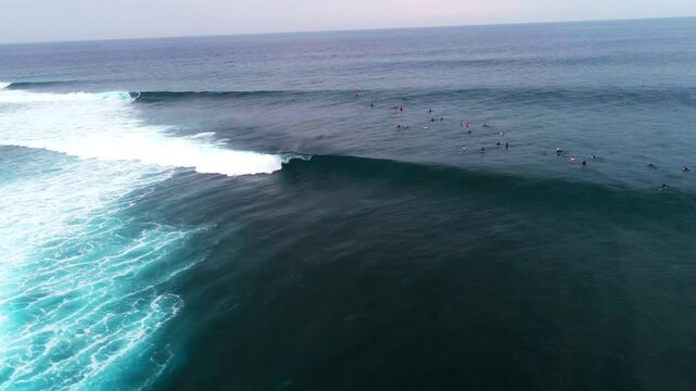 Drone pans above barreling wave and surfers at Cloudbreak Fiji