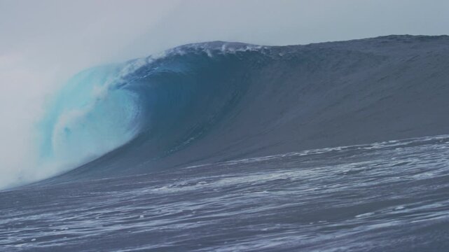 Slow motion tracking follows lip of wave crashing on ocean surface making empty barrel