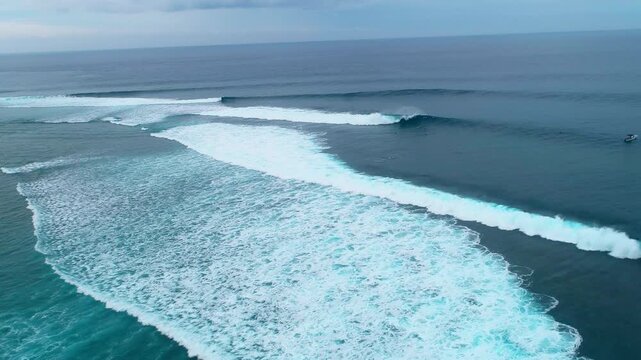 Aerial establishing overview of set waves breaking and barreling at Cloudbreak Fiji