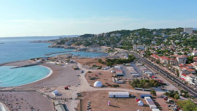 Marseille, France: Aerial view of Marina Olympique, main marina for Olympic Summer Games Paris 2024, flags of participating states flutter in wind - landscape panorama of Europe from above
