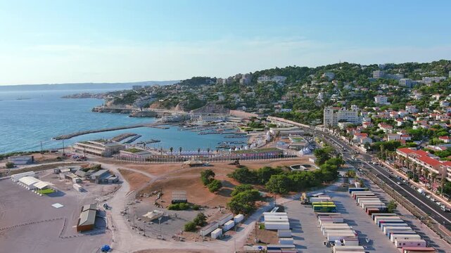 Marseille, France: Aerial view of Marina Olympique, main marina for Olympic Summer Games Paris 2024, flags of participating states flutter in wind - landscape panorama of Europe from above
