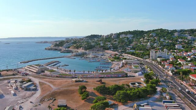 Marseille, France: Aerial view of Marina Olympique, main marina for Olympic Summer Games Paris 2024, flags of participating states flutter in wind - landscape panorama of Europe from above
