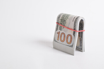 Rolled American dollars banknotes. Bundle of money roll of dollars isolated on white background, with clipping path. Stack of one hundred dollars American cash money bills rolled up with rubber band