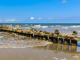 Wellenbrecher aus Holz am Sandstrand 