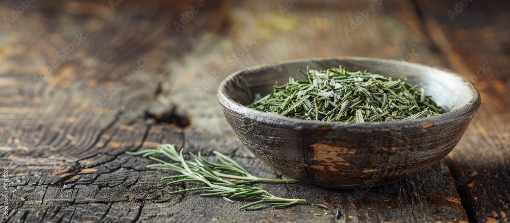 Poster tarragon dried in a bowl on a wooden table with copy space image