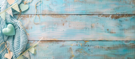 Invitation concept for a baby boy shower on a soft blue and wooden background with a banner and ample copy space image photographed from above