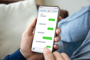 man hands hold phone with app messenger on the screen