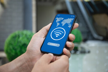 male hand holding phone with wifi connect app background office