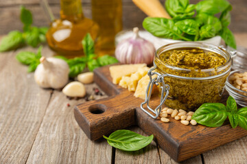 Pesto. Italian basil pesto sauce on a textured wooden background. Ingredient for pesto sauce: fresh...
