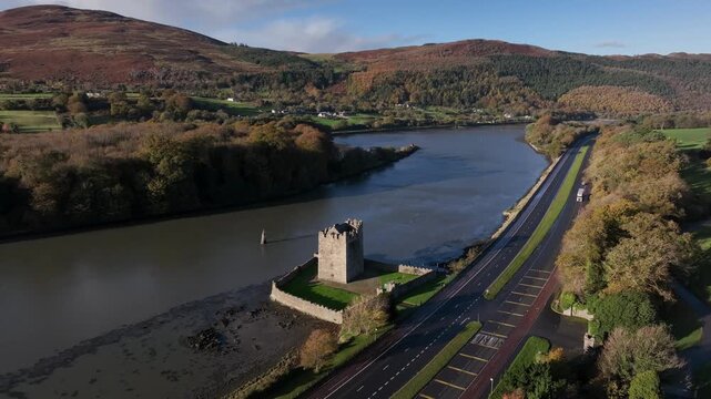 Narrow Water Castle, County Down, Northern Ireland, November 2022. Drone clockwise orbit of the Tower House on the Newry river revealing 19th Century Elizabethan Revival Castle in the background.