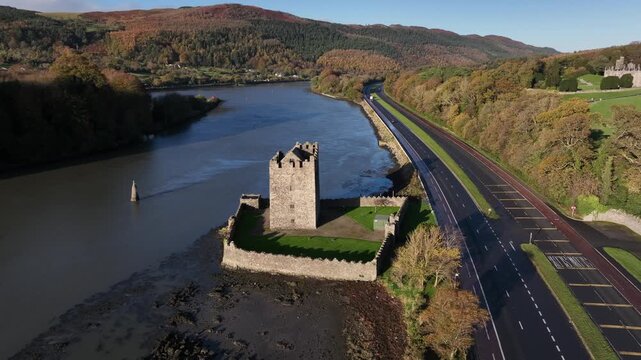 Narrow Water Castle, County Down, Northern Ireland, November 2022. Drone orbits Tower House counter clockwise on the Newry river with the Black Mountain in the background.