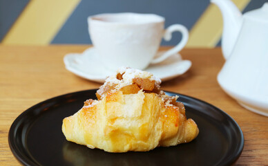 Delectable Caramel Apple Cream Cheese Croissant with Blurry Teacup in the Backdrop