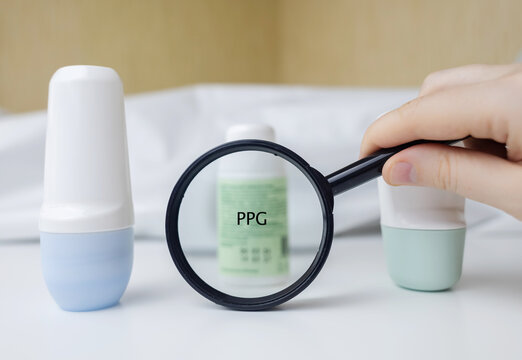 PPG in deodorant. Dangerous components and ingredients in care cosmetics. Protection of armpits from sweating. Antiperspirants on the table, viewed under a magnifying glass