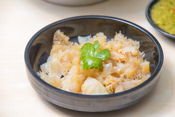 Jellyfish Salad with sesame oil and roasted chilli-in-oil paste on the black dish.