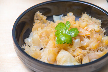 Jellyfish Salad with sesame oil and roasted chilli-in-oil paste on the black dish.