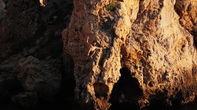 Tracking shot of a man executing a perfect frontflip off a 7m cliff into gorgeous turquoise water of the sea of the east coast of Spain
