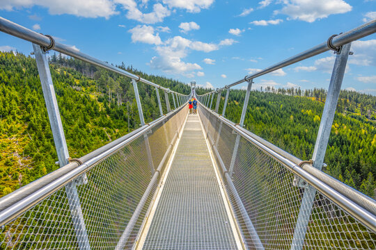 The Sky Bridge 721 is the worlds longest suspension footbridge in Dolni Morava Resort, Czechia. Visitors enjoy scenic forest views as they walk.