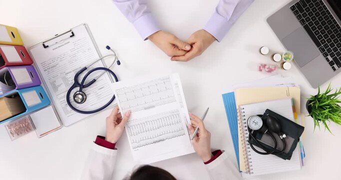 Doctor examines papers with analysis results at appointment