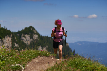 Woman hiker with poles and backpack