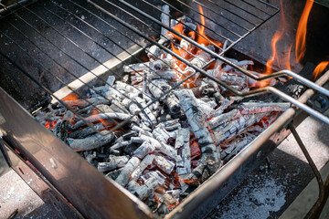 An image of a grill with glowing embers and burning flames, showcasing the intense heat and readiness for grilling or BBQ activities. Perfect for summer cookouts or outdoor cooking scenes