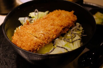 Tonkatsu are thick pork cutlets breaded with flour, egg, and bread crumbs and then deep-fried in oil.