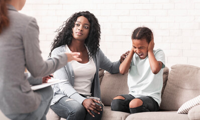 Parenting a Difficult Child Concept. Caring black mother comforting her naughty little daughter at...