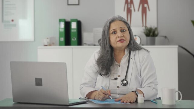 Indian female senior doctor giving medicine to the patient