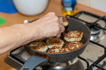Meat burgers or cutlet-shaped patty being shallow fried in oil on a frying pan, close up. version of cutlets - kotlety.