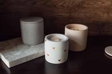 Aromatic premium soy candles in gray and pink concrete jar on wood background. Banner for candle shop. Mock up