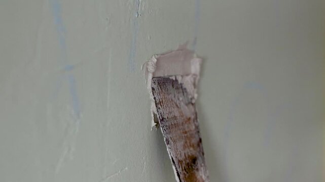 Professional wall repair using joint compound and putty knife, Home improvement renovation project: filling wall cracks with spackle. Smoothing drywall to cover holes for painting. 4k video footage 