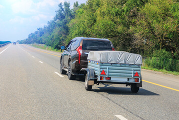 SUV with a trailer moves along a road © Yuri Bizgaimer