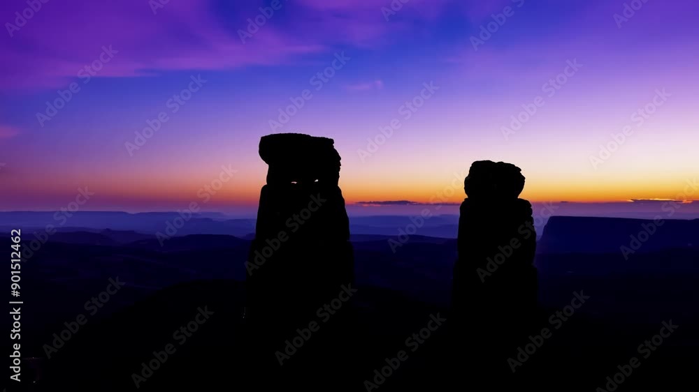 Poster high above the monoliths the last traces of light in the sky create a stunning contrast against the 