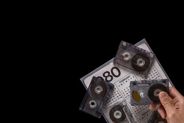 Fototapeta premium Man with old calendar and audio tape cassette having nostalgia of 80s music. 1980 calendar and audio cassette, reflecting the vintage tech and nostalgic ambiance of the late 20th century