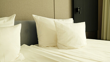 Close-up fragment of bedroom with empty bedside table, reading lamp and a USB socket in modern interior​ design home or hotel. Soft pillow and blanket, stylish comfortable furniture. 