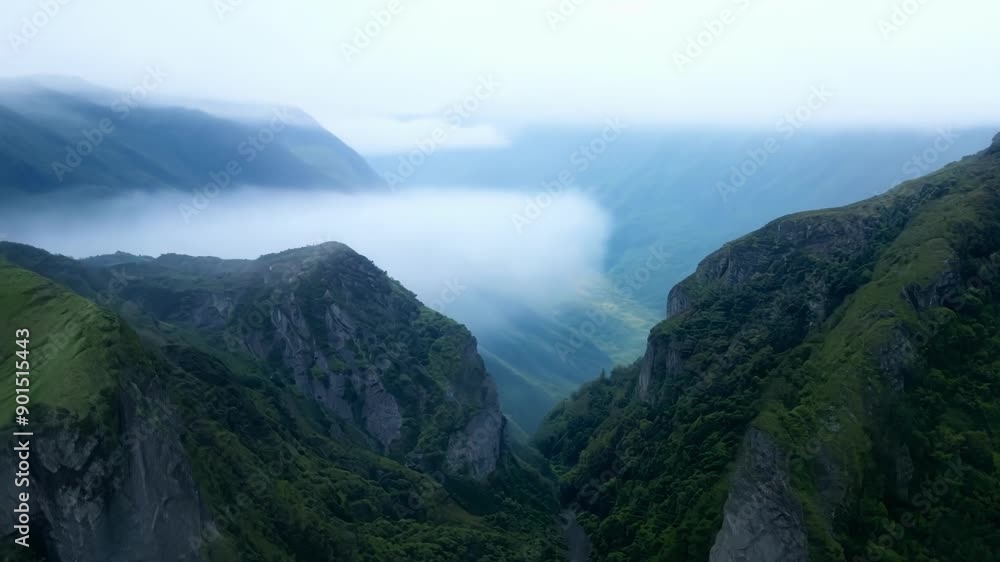Poster aerial shot of misty mountain valleys with layers of fog cascading down the slopes.