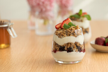 Yogurt with crispy granola, berries and honey for a delicious breakfast. Healthy eating.