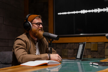 A modern podcast host wearing headphones in a professional recording studio setting