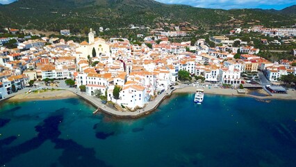 Fototapeta premium aerial view over the Badia de Cadaqués, to the old white houses of Cadaqués and the church Santa Maria de Cadaqués, Port Alguer and the Mediterranean Sea, Girona, Catalonia, Spain