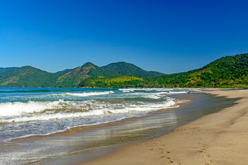 Obraz premium Panoramic image of Bonete beach in Ilhabela with the sea, hills and forests surrounding it