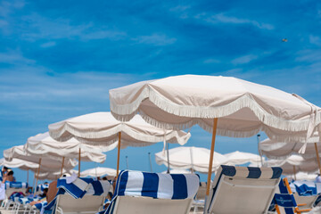 Beige parasol and striped chairs by the beachfront at Miami Beach.