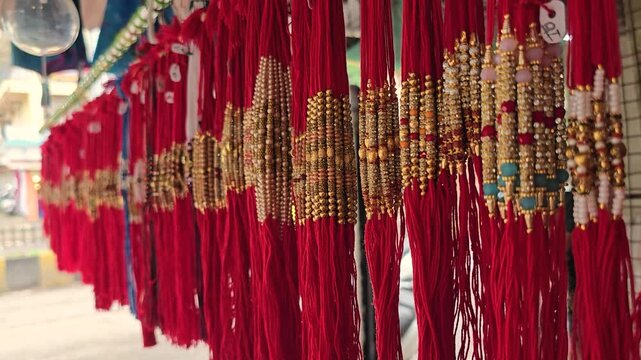 Close up shot of Red Color threads Rakhi hanging on store. Indian festival Raksha bandhan Rakhi