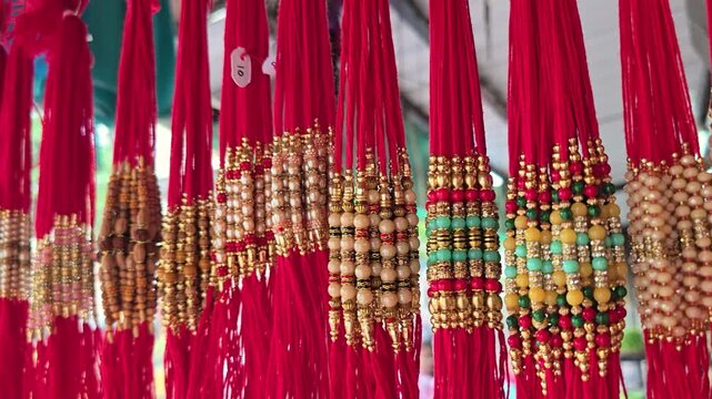 Close up shot of Red Color threads Rakhi hanging on store. Indian festival Raksha bandhan Rakhi