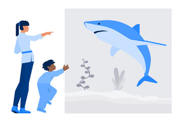 Woman and boy looking at a shark in aquarium
