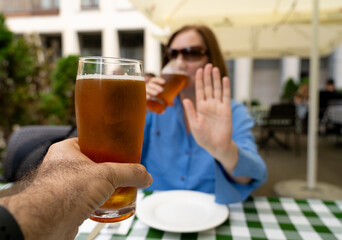 Reject a glass of beer, woman refusing alcohol, stop drinking, sobriety concept, saying no to beer glass