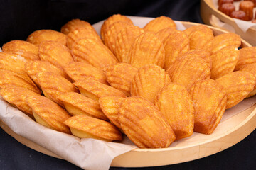 Madeleines or french tea cakes in a basket, spongy texture cookies, golden soft biscuits, tea snacks