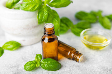 Basil essential oil on a textured wooden background. Basil essential oil and fresh leaves. Aromatherapy. Aroma oil. Medical herbs. Alternative medicine. Place for text. Copy space.